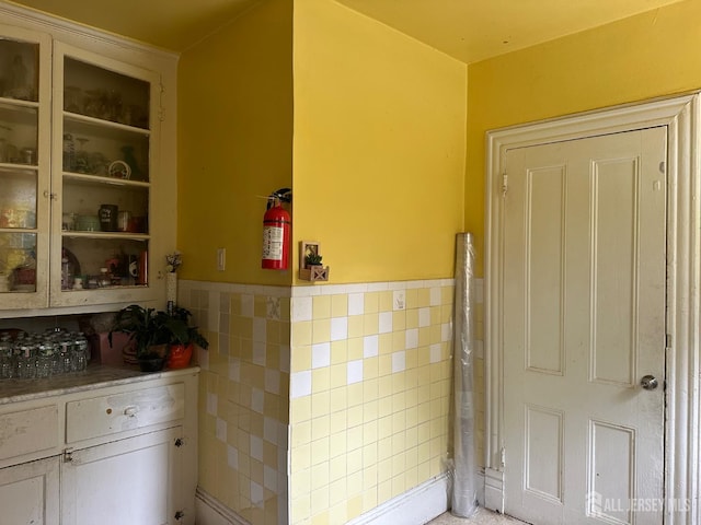 290 Redmond St, New Brunswick, NJ 08901 - kitchen featuring tile walls, a wainscoted wall, glass insert cabinets, and white cabinetry