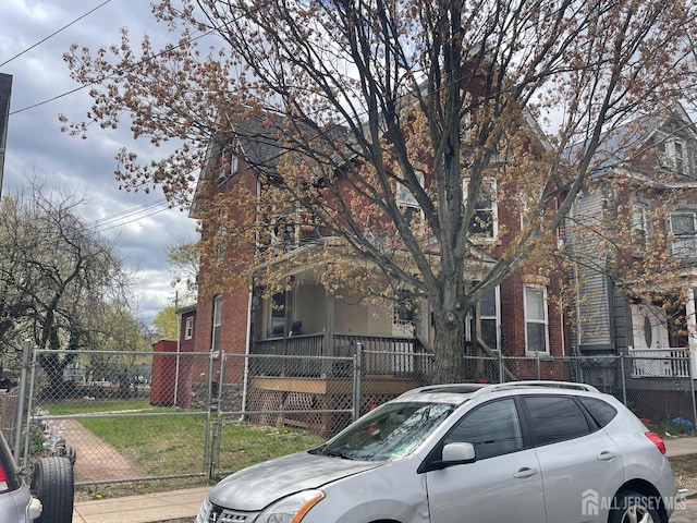 290 Redmond St, New Brunswick, NJ 08901 - obstructed view of property with a fenced front yard, brick siding, covered porch, and a gate
