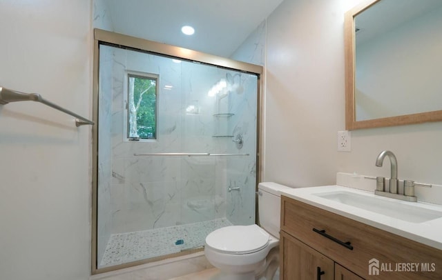 bathroom featuring vanity, toilet, and a shower with shower door