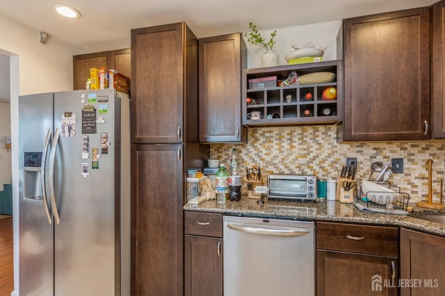 kitchen with a toaster, appliances with stainless steel finishes, stone counters, and decorative backsplash