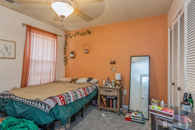 bedroom with carpet, a closet, visible vents, and a textured ceiling