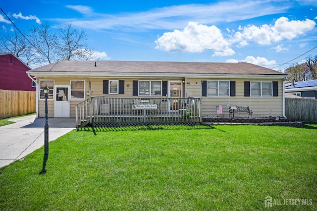 ranch-style home with a front lawn, concrete driveway, and fence