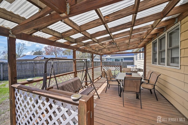 wooden terrace with a fenced backyard and outdoor dining area