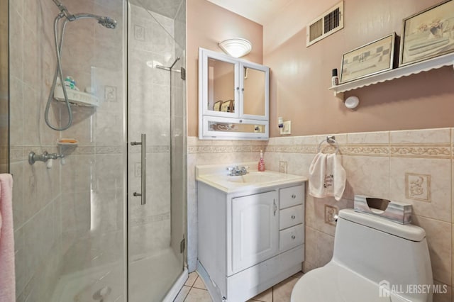 bathroom with toilet, a stall shower, tile walls, visible vents, and tile patterned flooring