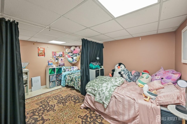 carpeted bedroom with a paneled ceiling