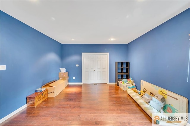 unfurnished room featuring wood finished floors, baseboards, and recessed lighting