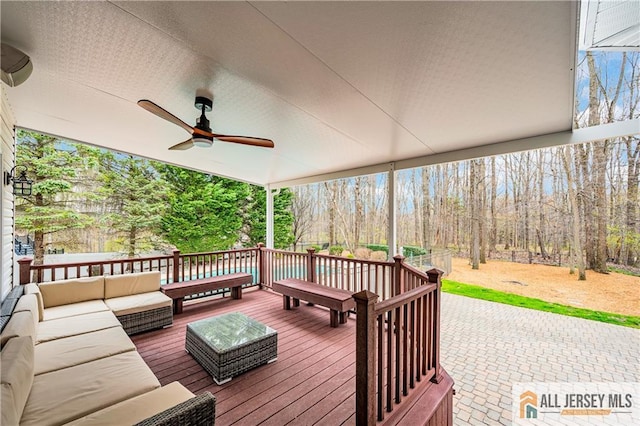 deck with outdoor lounge area and a ceiling fan