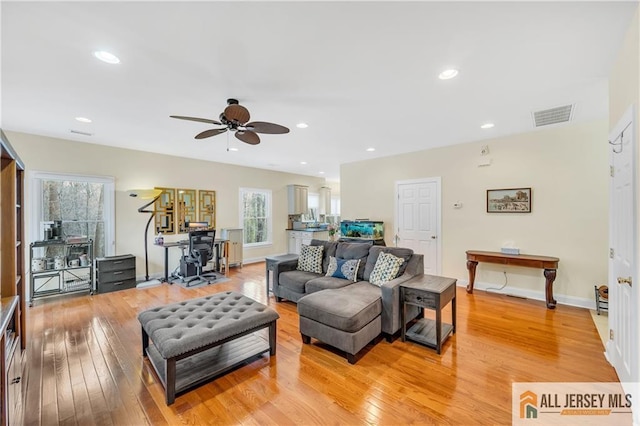 living area featuring a ceiling fan, light wood-type flooring, baseboards, and recessed lighting