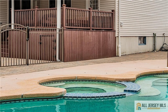 view of swimming pool featuring a pool with connected hot tub