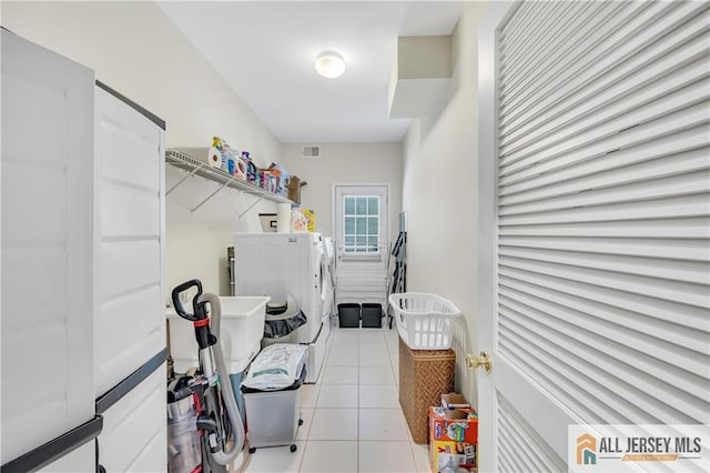 washroom with washer and dryer and light tile patterned floors