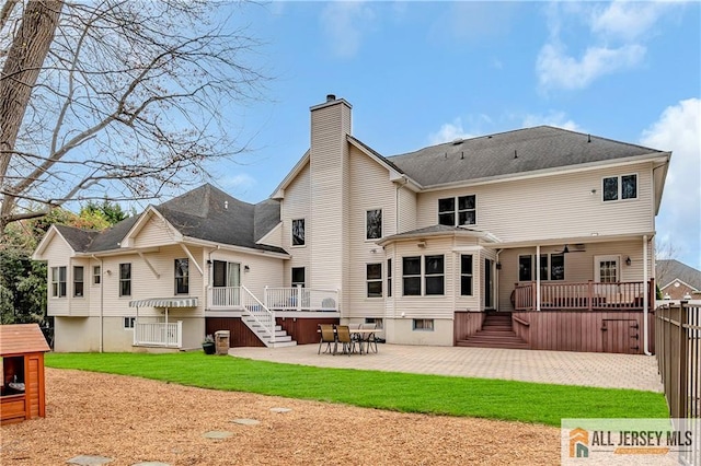 back of property with a chimney, stairs, a patio, a wooden deck, and fence