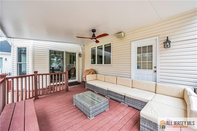 wooden deck with an outdoor living space and a ceiling fan