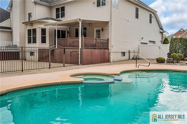 view of pool featuring a gate, a pool with connected hot tub, and a patio area