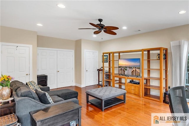 living room featuring ceiling fan, light wood finished floors, and recessed lighting