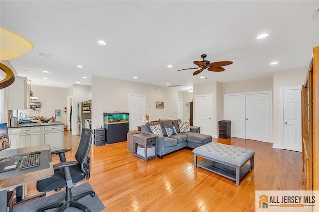 living area with ceiling fan, light wood-type flooring, an office area, and recessed lighting