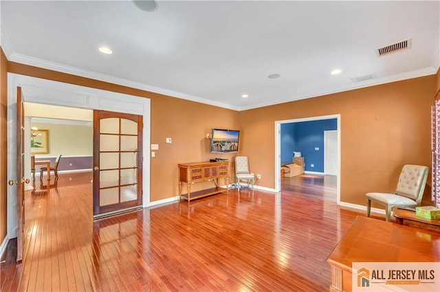 living area featuring hardwood / wood-style flooring, crown molding, baseboards, and recessed lighting