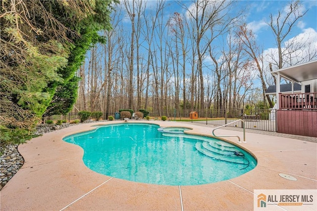 view of swimming pool featuring fence, a patio, and a pool with connected hot tub