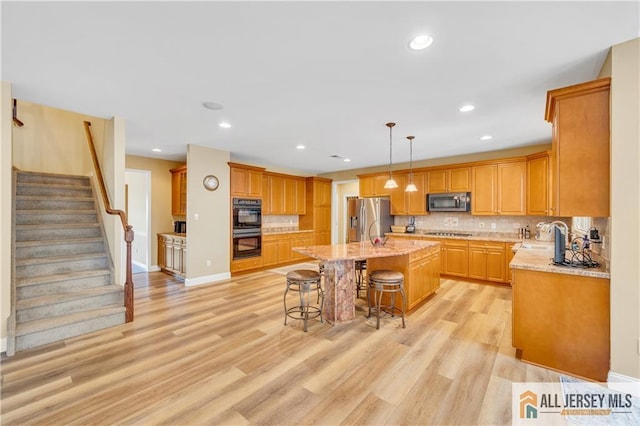 kitchen with stainless steel appliances, a breakfast bar, backsplash, light stone counters, and recessed lighting