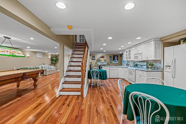 kitchen with white appliances, white cabinetry, light wood-style flooring, pool table, and recessed lighting