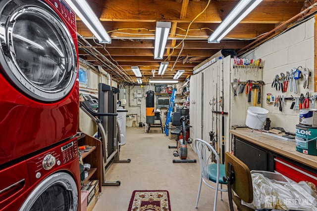 unfinished basement with stacked washer / dryer and a workshop area