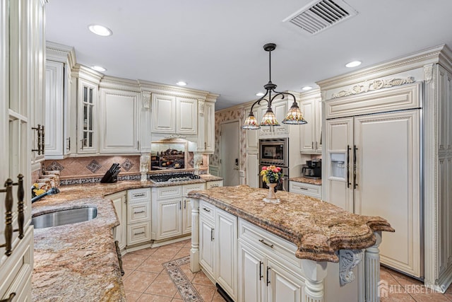 kitchen featuring light tile patterned flooring, built in appliances, tasteful backsplash, recessed lighting, and a center island