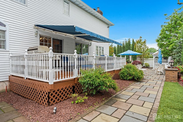 rear view of house featuring a wooden deck and a chimney