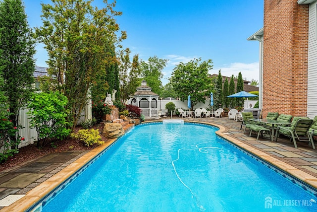 view of pool with a gazebo, a fenced backyard, a patio, and an outdoor hangout area