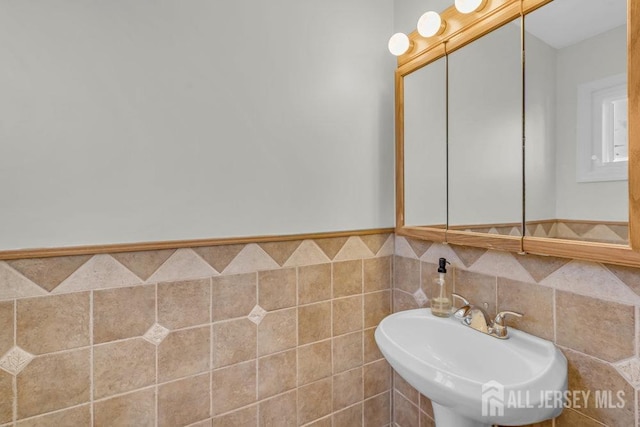 bathroom featuring tile walls and sink