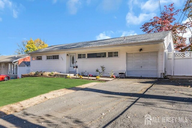 ranch-style home with a garage and a front yard