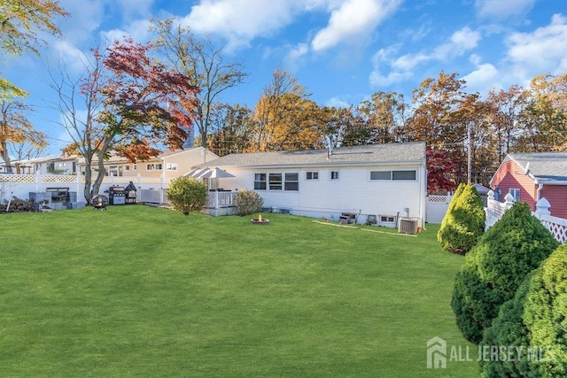 back of house with a lawn and central AC