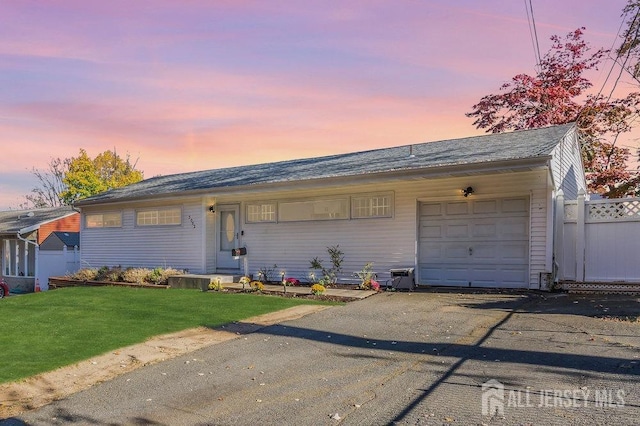 ranch-style home with a yard and a garage