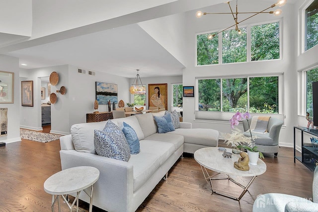 107 Sayre Dr, Plainsboro, NJ 08540 - living room with a chandelier, healthy amount of natural light, a towering ceiling, and wood finished floors