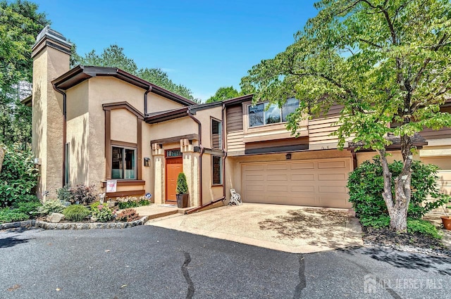 107 Sayre Dr, Plainsboro, NJ 08540 - view of front of house with driveway, an attached garage, stucco siding, and a chimney