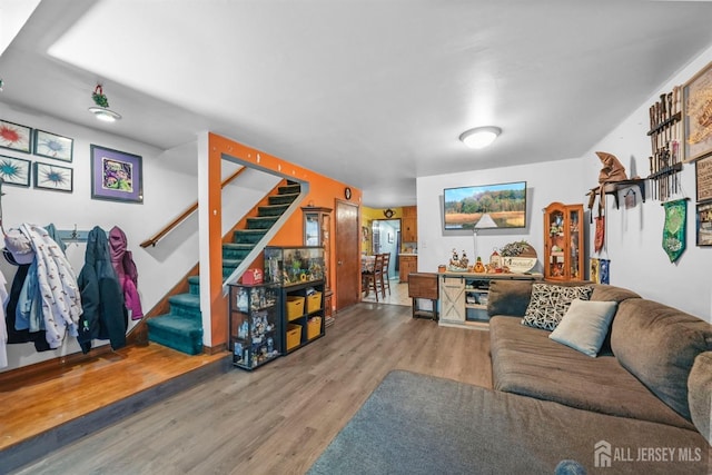 living room with stairs and wood finished floors