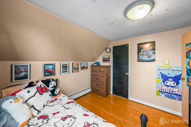 bedroom featuring lofted ceiling, baseboards, a baseboard heating unit, and wood finished floors