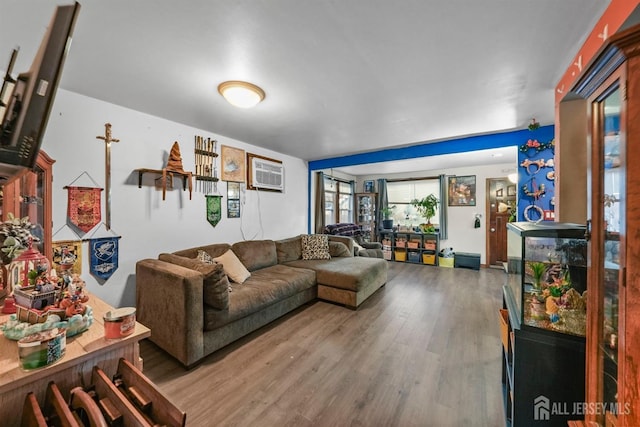 living room featuring an AC wall unit and wood finished floors