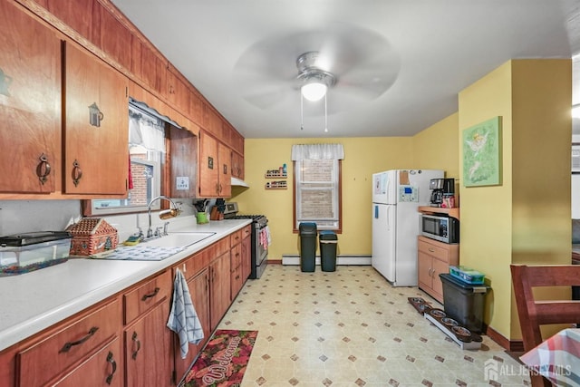 kitchen featuring a sink, a ceiling fan, light countertops, appliances with stainless steel finishes, and light floors