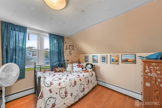 bedroom with vaulted ceiling, baseboard heating, and wood finished floors