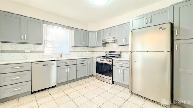 1204 Maplecrest Rd, Edison, NJ 08820 - kitchen with stainless steel appliances, under cabinet range hood, a sink, tasteful backsplash, and light countertops