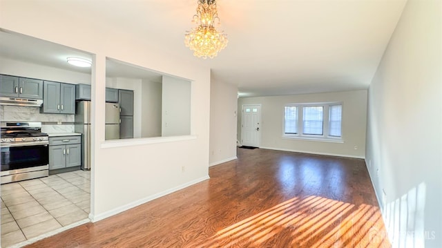 1204 Maplecrest Rd, Edison, NJ 08820 - unfurnished living room featuring light wood-style floors, a chandelier, and baseboards