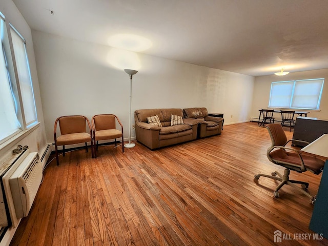 138 The Orchards Unit C, East Windsor, NJ 08512 - living room featuring hardwood / wood-style flooring, healthy amount of natural light, and a baseboard heating unit
