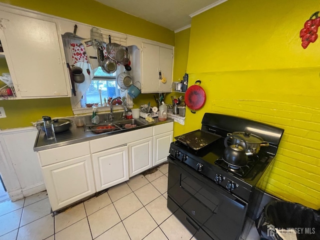 kitchen with a sink, crown molding, black range with gas cooktop, light tile patterned floors, and white cabinets