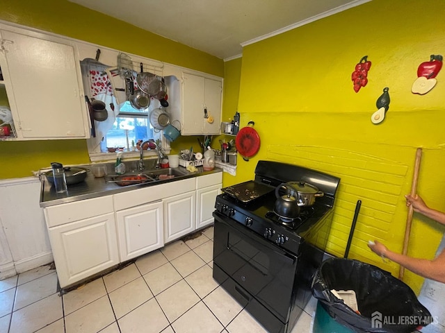 kitchen with white cabinets, black gas range, light tile patterned flooring, and a sink
