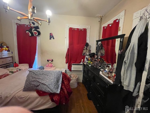 bedroom featuring an AC wall unit and wood finished floors