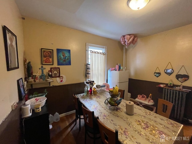 dining area with radiator and dark wood-style flooring