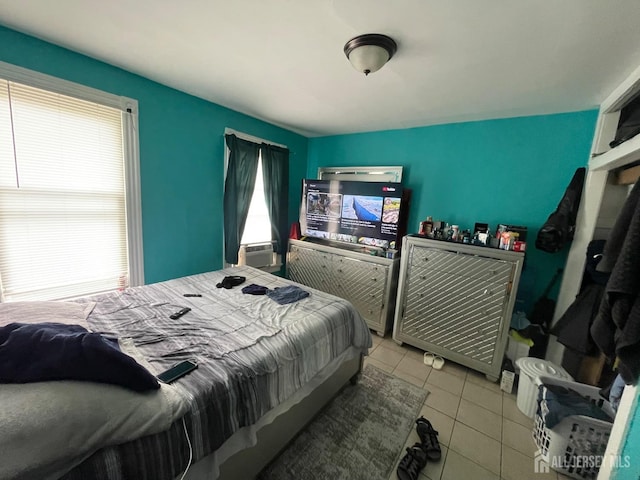 bedroom with light tile patterned floors, multiple windows, and cooling unit