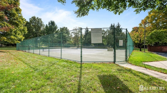 view of sport court with a yard