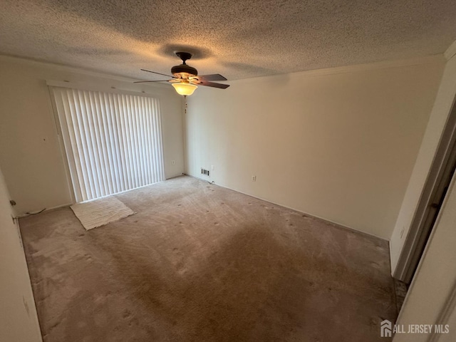 carpeted spare room with ceiling fan and a textured ceiling