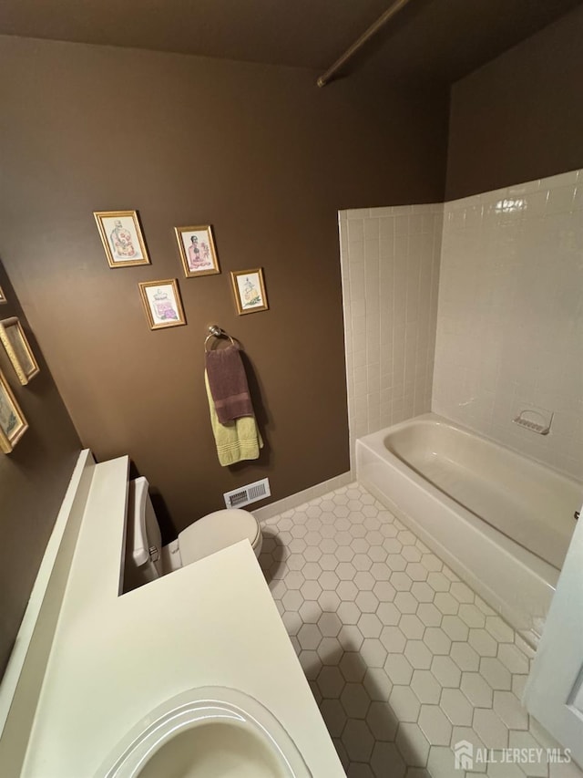 bathroom with tile patterned floors, toilet, a bathing tub, and sink