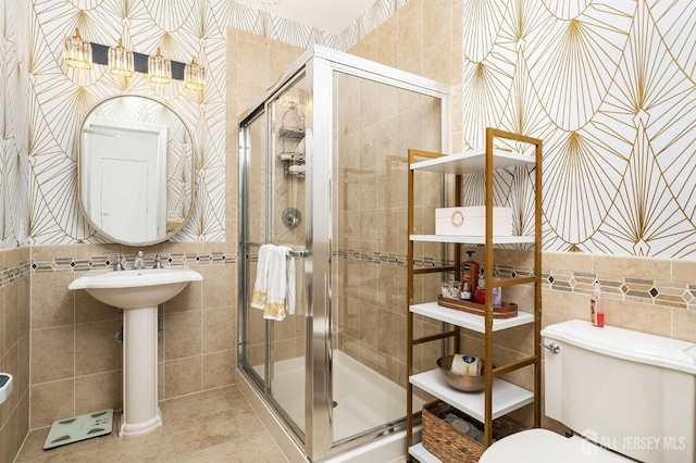 full bath with tile patterned flooring, toilet, a stall shower, and tile walls